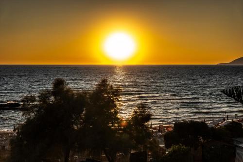 um pôr do sol na praia com o pôr do sol em Hotel Acciaroli em Acciaroli