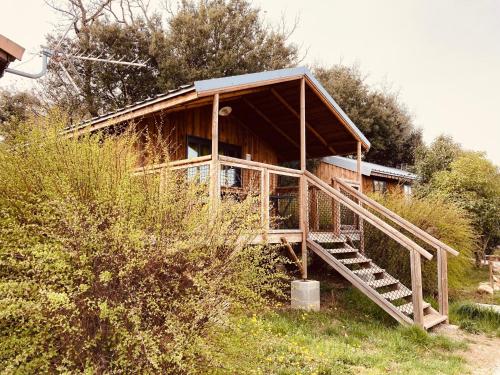 a small wooden house with a staircase leading to it at Lodges du Ushuaïa Villages Camping les 4 Saisons in Grane
