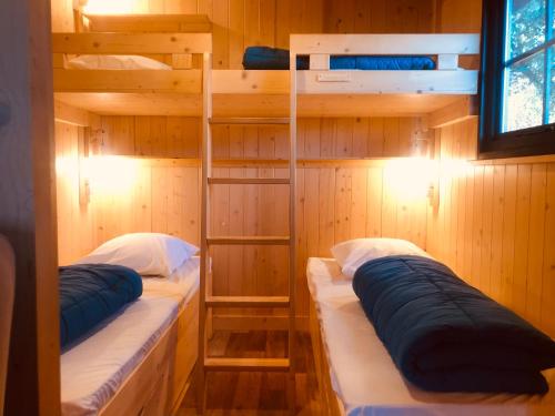 a room with two bunk beds in a cabin at Lodges du Ushuaïa Villages Camping les 4 Saisons in Grane