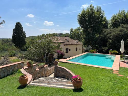 a house with a swimming pool in a yard at Masia Can Viver - Olive oil tourism B&B in Bigues i Riells