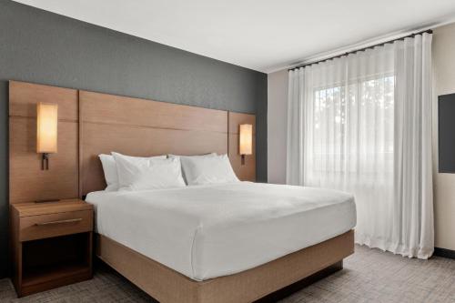 ein Schlafzimmer mit einem großen Bett und einem Fenster in der Unterkunft Residence Inn by Marriott Laval in Laval