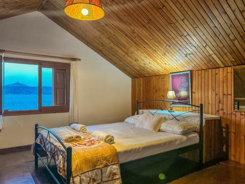 1 dormitorio con 2 camas en una habitación con ventana en Fisherman's House, en Sinoikismós Plakálona