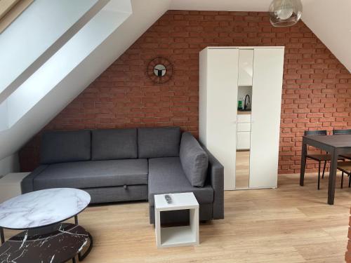 a living room with a couch and a brick wall at Apartament w górach in Mszana Dolna