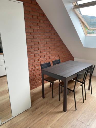 a table and chairs in a room with a brick wall at Apartament w górach in Mszana Dolna