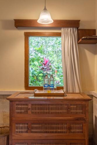 a window with two bottles on top of a wooden dresser at Nusa Indah Candidasa in Candidasa