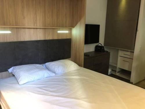 une chambre avec un grand lit blanc et une télévision dans l'établissement Wonderful Studio in Heart of Paris, à Paris