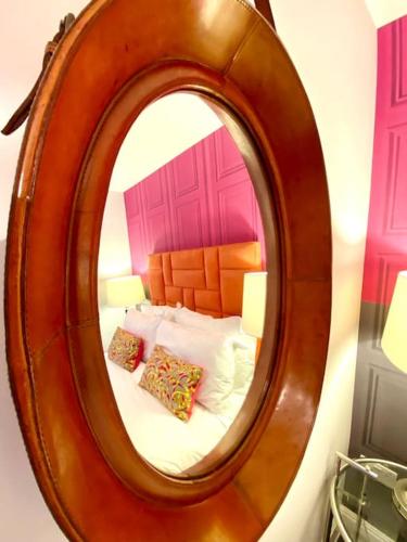 a mirror in a room with a bed with pillows at Incredible Apartment - Amazing Location - Free Parking & WiFi! in Poole