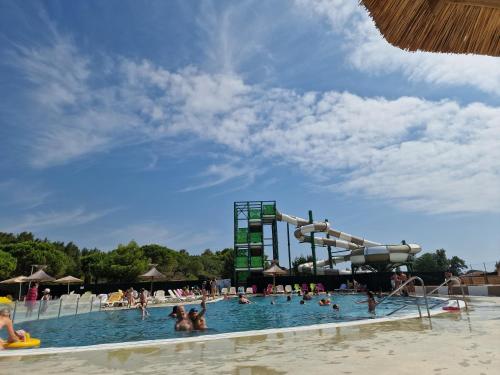 une grande piscine avec un toboggan dans l'établissement Mobilhome Clim Télé La Falaise 4 étoiles, à Narbonne