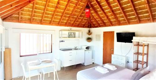 a room with a kitchen with a bed and a table at Mandala Bungalows - Adults Only in Los Caños de Meca