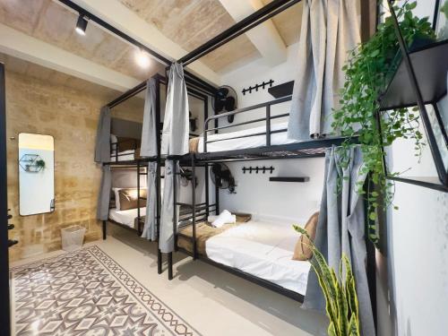 a room with four bunk beds in a building at Mandera's Boutique Suites & Dorms in Valletta