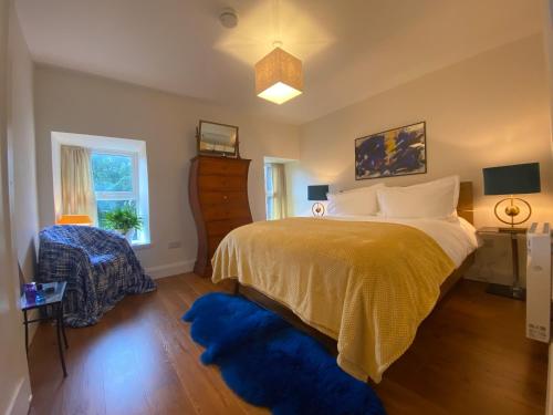 a bedroom with a large bed with a blue rug at Berlin Wall Apartment at The Residence Bantry in Bantry
