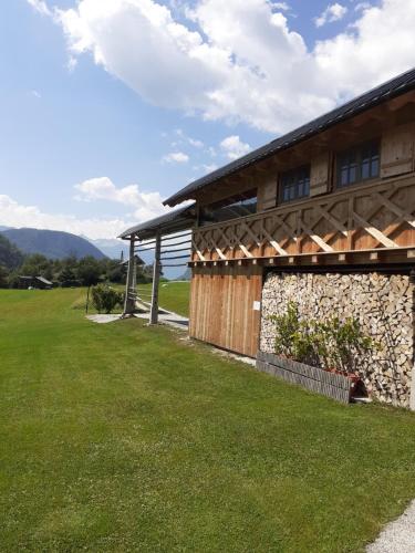 a house with a grass yard next to a building at Soba pri Bregarju in Bohinj