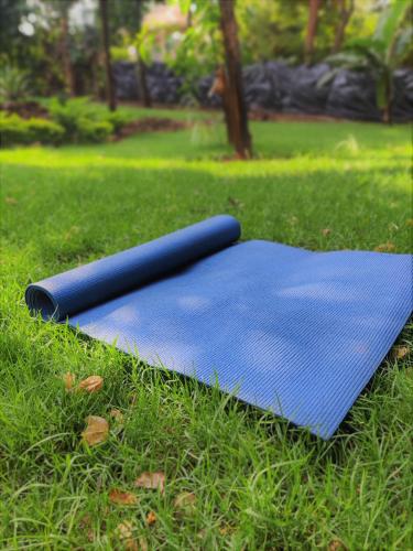 a blue yoga mat sitting on the grass at Hostel Kiliwood in Moshi