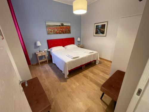 a bedroom with a white bed and a red headboard at Lady Verona Residence in Verona