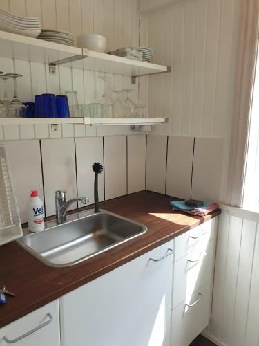 a kitchen with a sink and a wooden counter top at St. Strandbygaard in Åkirkeby