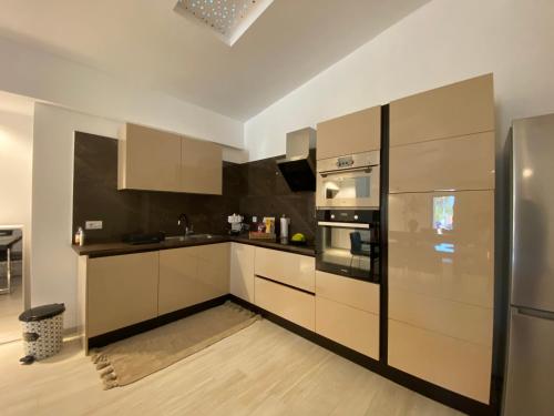 une cuisine avec des armoires blanches et des appareils en acier inoxydable dans l'établissement elea resort 2, à Prévéza