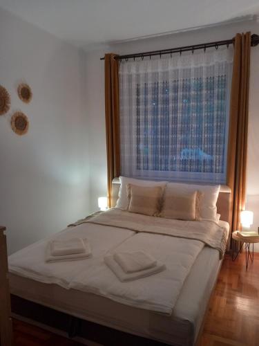 um quarto com uma cama com uma janela e 2 almofadas em Boglárka Vendégház Tiszalök em Tiszalök