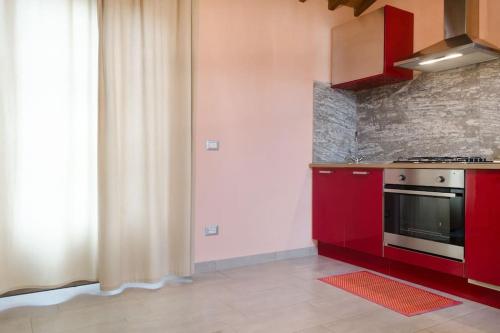 een keuken met rode kasten en een fornuis bij Monolocale per due Agriturismo le Pinete in Riotorto