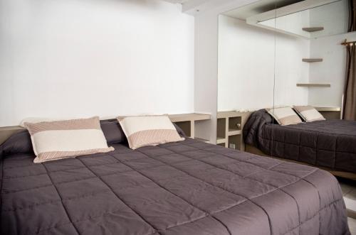 - une chambre avec 2 lits et une grande fenêtre dans l'établissement Edificio Correa, à Mendoza