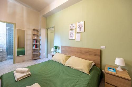 1 dormitorio con 1 cama grande con manta verde en [Abbiategrasso center] comfort, Wi-fi e netflix, en Abbiategrasso