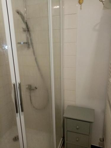 une salle de bain avec une douche avec une porte vitrée dans l'établissement Les Toiles du Figuier, à Espéraza