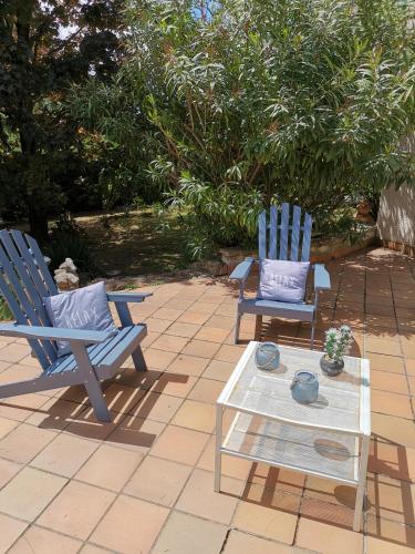 - 2 chaises bleues et une table basse sur la terrasse dans l'établissement La provence, à Saint-Prim