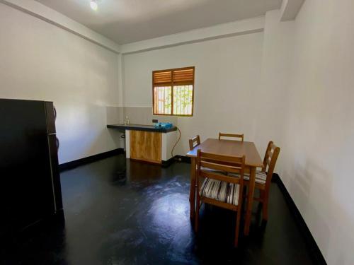Zimmer mit einem Tisch und Stühlen sowie einer Küche in der Unterkunft Home Stay Polhena in Matara