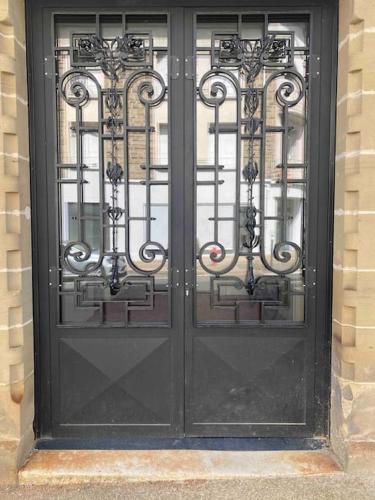 une porte noire sur un bâtiment avec du verre dans l'établissement #Le Jaurès - Studio à la Gare - Neuf et Lumineux, à Brive-la-Gaillarde