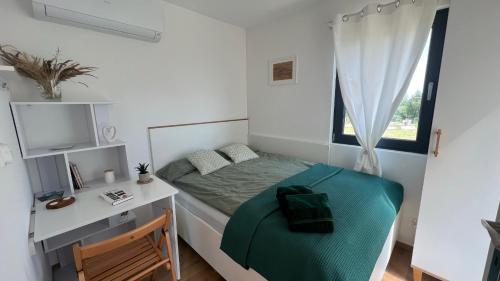 um quarto com uma cama, uma secretária e uma janela em W Kręgu Natury 