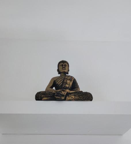 una estatua de un hombre sentado en una pose de meditación en Después del mar / aeropuerto, en La Paz