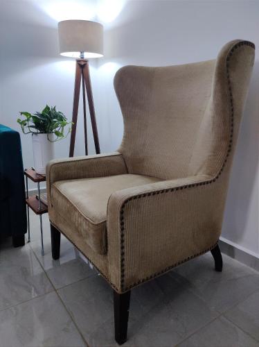 une chaise brune dans une chambre avec lampe dans l'établissement Después del mar / aeropuerto, à La Paz