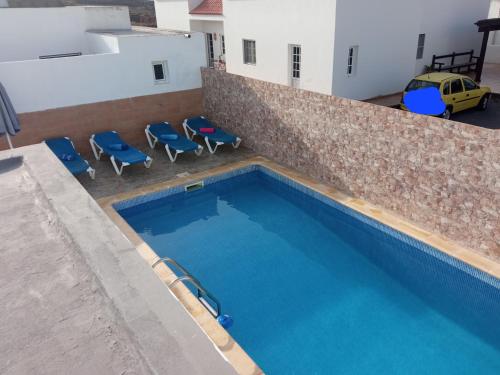 una vista aérea de una piscina con sillas azules en Casa tomas C, en Villaverde