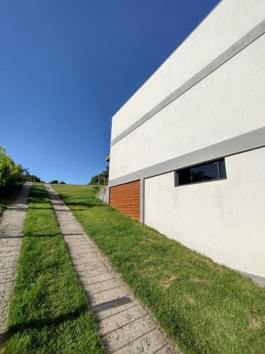 a house with a pathway next to a building at Suítes do Vale - Praia do Rosa in Imbituba