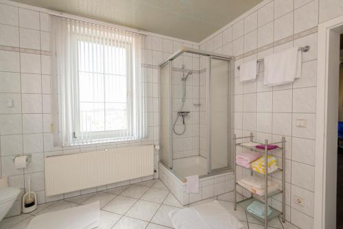 La salle de bains est pourvue d'une douche, d'une baignoire et d'un lavabo. dans l'établissement Villa Regina Fürstensuite, à Friedrichroda