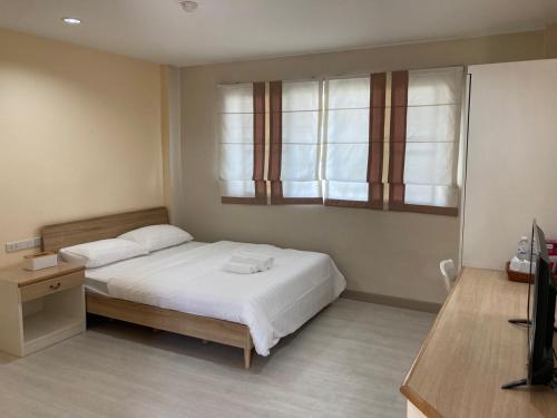 a bedroom with a bed and a window at บ้านศรีแบริ่ง in Bangna