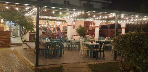 un restaurante con mesas y sillas bajo un dosel con luces en PLAYA BLANCA BED AND BREAKFAST, en Bayahibe