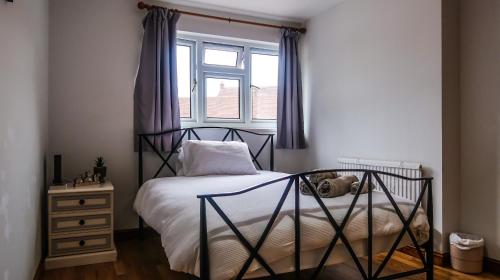 a bedroom with a bed with a dog laying on it at Cozy double room - Only room in London