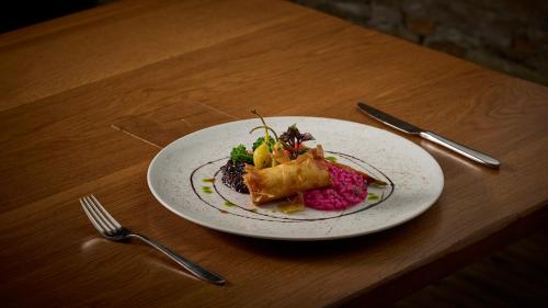 a plate of food on a table with a fork and knife at Aspen Alpine Lifestyle Hotel in Grindelwald