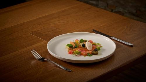 a plate of food on a table with a fork and knife at Aspen Alpine Lifestyle Hotel in Grindelwald