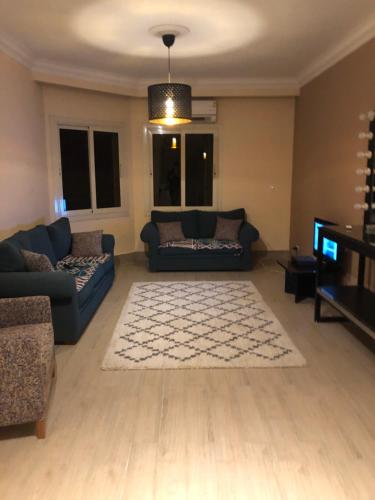 a living room with two couches and a television at Duplex villa in 6th Of October