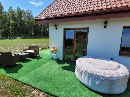 a house with a yard with a green lawn at Kemping i Domki nad stawem in Harsz