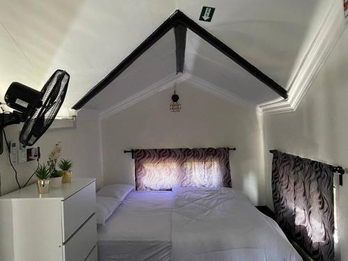 a bedroom with a white bed with a black and white canopy at Abe cottage in Kuala Besut