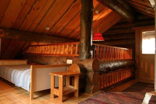 1 dormitorio con 1 cama en una cabaña de madera en Kelola Cottage, en Keyritty