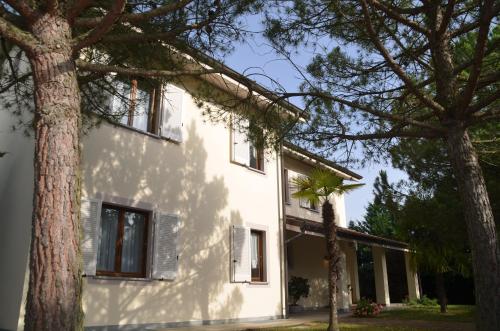a white house with trees in front of it at Villa Patrizia in Moncalvo