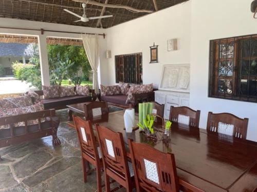 a living room with a wooden table and chairs at Lion Garden Villa 6 in Malindi