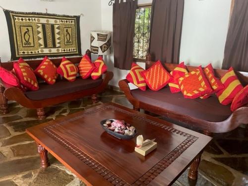 a living room with two couches and a table at Lion Garden Villa 6 in Malindi