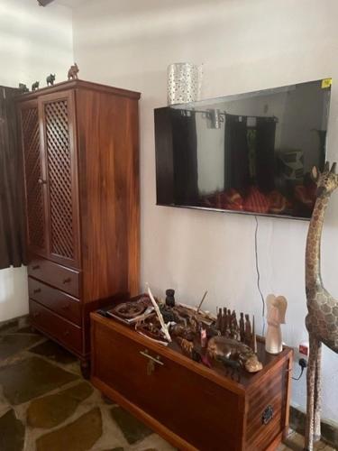 a room with a dresser and a mirror and a giraffe statue at Lion Garden Villa 6 in Malindi