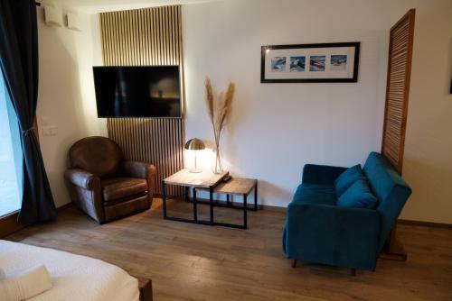 un salon avec un canapé bleu et une chaise dans l'établissement Résidence Emeraude - Centre Village - AravisTour, à Saint-Jean-de-Sixt