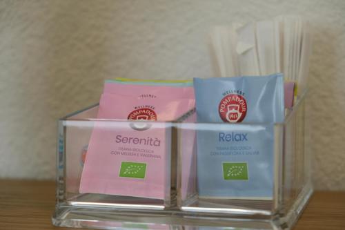 a glass container with three packets of soap at TANIT ROOMS & SPA in Villasimius