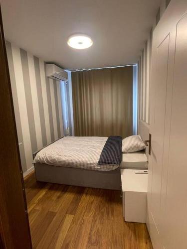 a small bedroom with a bed in a room at Pleasant apartment with panoramic view in Prizren